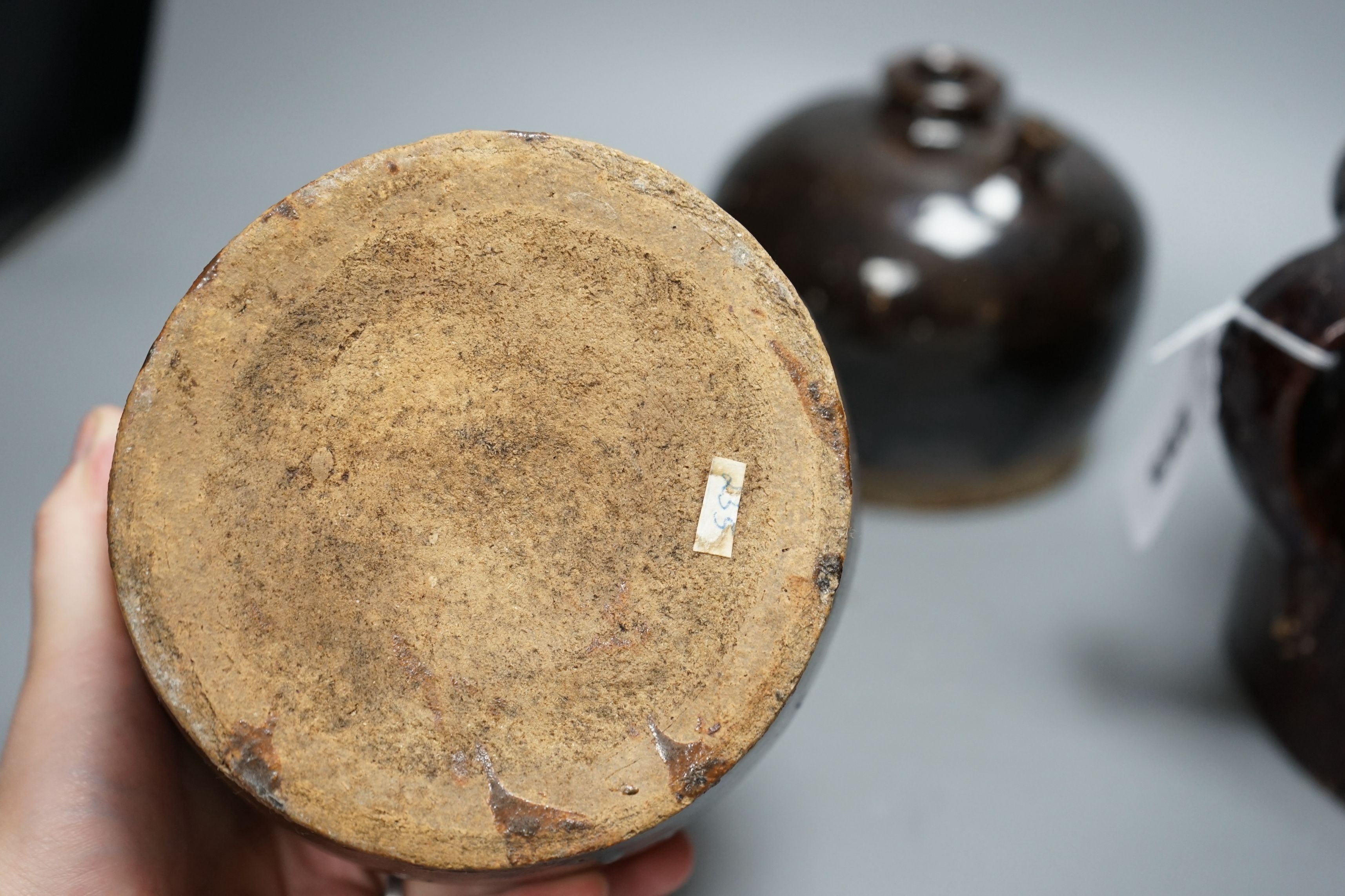 Two 19th century Chinese tenmoku glazed soy sauce jars, a similar jar and a pouring vessel, largest 14cm tall